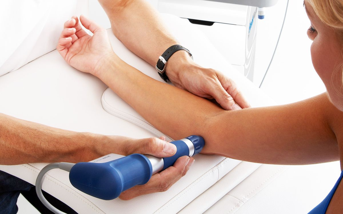 Profissional aplicando terapia em tendão do joelho